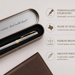 May include: A silver Parker pen with gold accents, engraved with "Carl Radarcich," rests in an open, metallic case. The case is lined with black fabric and features the inscription "Act with vision, lead with heart."