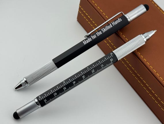 A 6-in-1 engraved multi-tool pen presented in a leather gift box — genuinely clever desk-to-field gadget that looks way more expensive than it is.