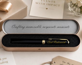May include: A black pen with gold detailing is presented in a rose gold case with black foam lining. The case lid reads "Crafting memorable corporate moments." The pen is engraved with "Carl Radeveich."