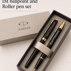 May include: A Parker IM ballpoint and roller pen set in a dark gray box. The black pens feature gold-tone accents and are engraved with the name Ryan O'Donnell. The text Option#2: IM ballpoint and Roller pen set is visible above the box.