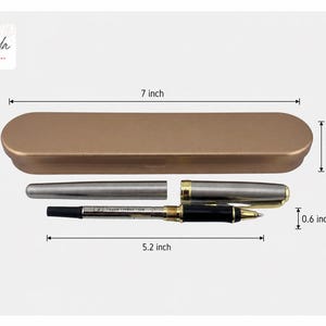 May include: A gold-colored pen case, 7 inches long, with a silver pen and a black and gold pen inside. The pens are partially disassembled. The pen case is 1.5 inches high, and the pen is 0.6 inches high.