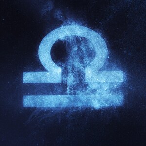 May include: A blue astrological symbol for the zodiac sign Libra, rendered in a starry, cosmic style against a dark blue background.