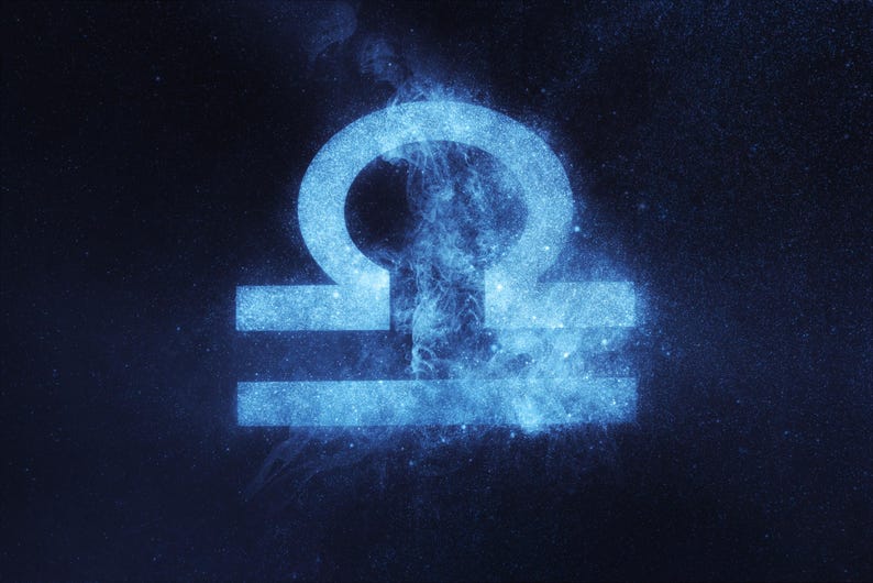 May include: A blue astrological symbol for the zodiac sign Libra, rendered in a starry, cosmic style against a dark blue background.