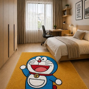 May include: A yellow rectangular rug featuring a cartoon character, Doraemon, in blue, white, red, and yellow. The rug is placed in a bedroom with a bed, desk, and window. The walls are light brown.