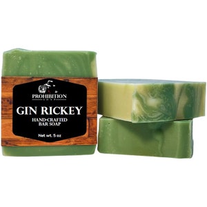 May include: Two bars of green and white hand-crafted soap with a label that reads "Prohibition Soap Gin Rickey Hand-Crafted Bar Soap Net wt. 5 oz."