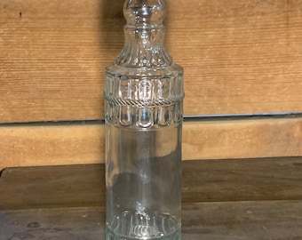 Salvaged clear pressed glass bottle. This unique bottle is vintage and salvaged for your creative reuse projects.