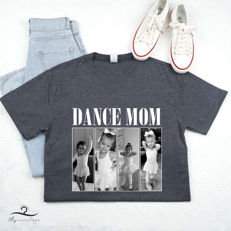 May include: A dark gray t-shirt with the text "DANCE MOM" printed in white. The shirt features three black and white photos of young girls in dance attire.