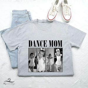 May include: Gray t-shirt with the text "Dance Mom" printed in black. The shirt features a photo collage of three young girls in dance attire.