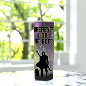 Puede incluir: Un vaso de acero inoxidable con un estampado de galaxia p&uacute;rpura y negro. El vaso presenta una silueta de un Mandaloriano y Grogu con el texto "Wherever I go he goes".