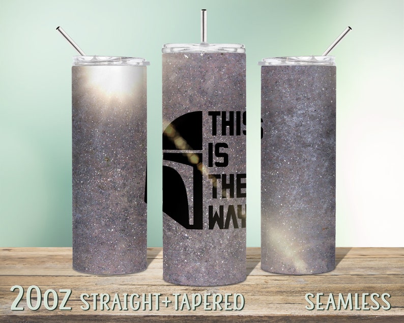 Pode incluir: Tr&ecirc;s copos de a&ccedil;o inoxid&aacute;vel de 20 oz com acabamento cinza brilhante. O copo do meio tem uma silhueta preta de um capacete mandaloriano e o texto "This is the way".