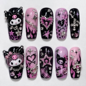 May include: A set of ten press-on nails featuring a black and pink color palette. The designs include 3D Kuromi character charms, silver metal cross charms, barbed wire accents, leopard print patterns, flames, stars, and rhinestones.