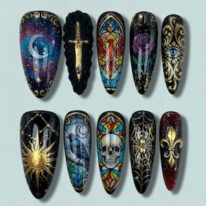 May include: A set of ten long, almond-shaped, painted fingernails. Designs include a crescent moon and stars, a sword, a stained-glass phoenix, a rose, an eye, a sun, a raven, a skull, a spiderweb, and a fleur-de-lis. Gold and jewel tones are used.