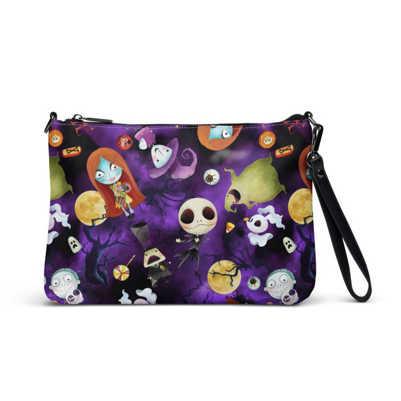 May include: A purple zippered pouch with a black strap. The pouch features a repeating pattern of characters from the Nightmare Before Christmas film, including Jack Skellington, Sally, and Zero. The characters are depicted in a cartoon style and are surrounded by Halloween-themed imagery, such as pumpkins, candy corn, and bats.