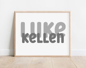 May include: A framed print with the name "LUKE" in large, gray, bubble letters and the word "KELLEN" in smaller, gray, bubble letters below.