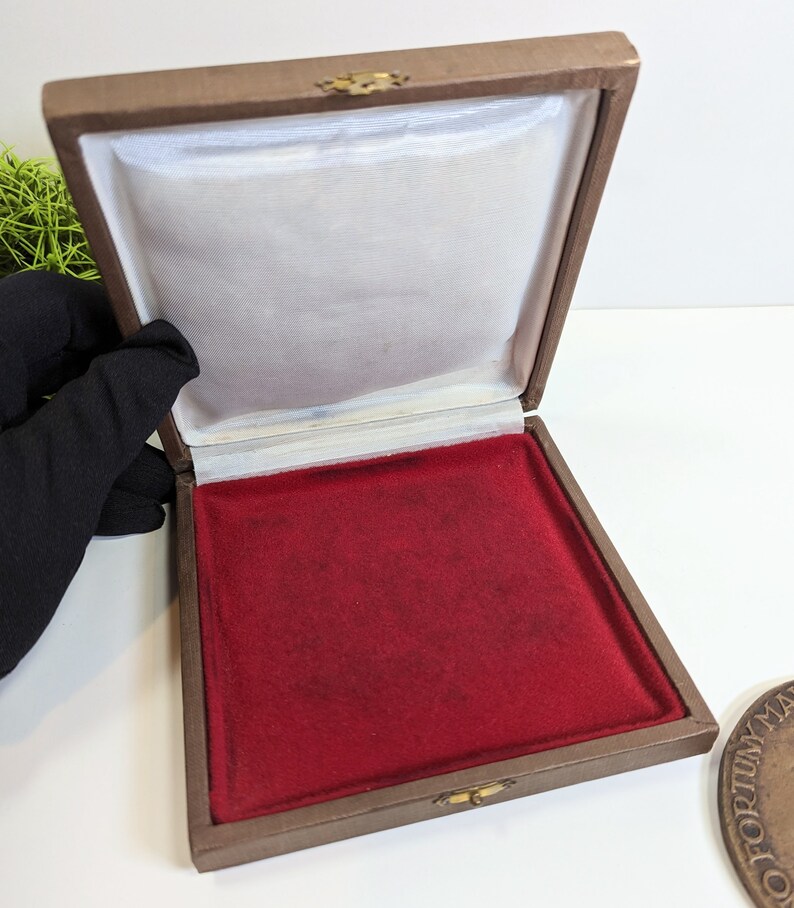 May include: A brown velvet-lined box with a red velvet interior. The box is open and empty.