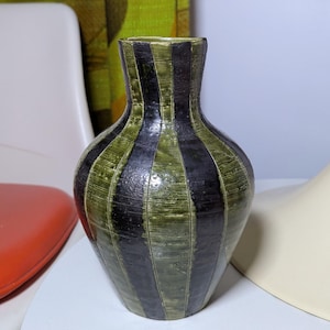 Peut inclure: Un vase en céramique rayé vert et noir avec un corps rond et un col étroit.