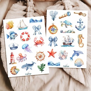 Op de afbeelding: Twee vellen stickers met een nautisch thema met aquarel illustraties van zeeleven en maritieme elementen. Ontwerpen omvatten een zeilboot, vis, krab, anker, kompas, zeepaardje en golven. De stickers zijn in verschillende kleuren.