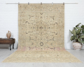 May include: A vintage beige rug with a floral pattern in shades of brown and pink. The rug has a distressed look and is perfect for adding a touch of traditional style to any room.