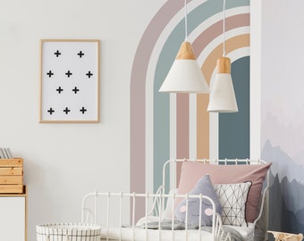 May include: A white metal bed frame with a pink and white patterned headboard and a rainbow wall decal. The bed is made with a white duvet and a pink pillow. There are two white pendant lights hanging from the ceiling.