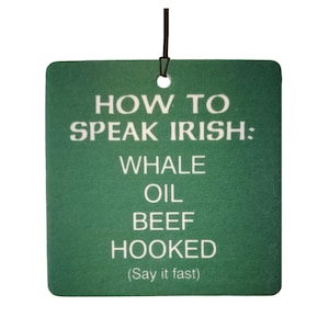 May include: Green car air freshener with white text that reads "How to Speak Irish: Whale Oil Beef Hooked (Say it fast)"