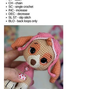 Puede incluir: Un juguete de Skye tejido a crochet en beige, rosa y naranja, con ojos negros y un sombrero rosa. La imagen incluye una lista de abreviaturas de crochet. El juguete es de la serie Paw Patrol.