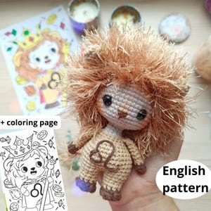 May include: A handmade crochet lion doll with a fluffy mane, brown eyes, and a Leo symbol on its chest. The doll is tan and brown, with a purple accent on its feet. Includes a coloring page with a lion illustration. The text "English pattern" is visible.