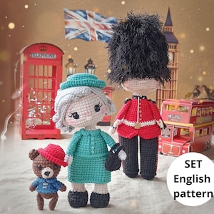 May include: A set of handmade crochet dolls and a bear, featuring a Queen, a Royal Guard, and a bear in a red hat. The dolls are in front of a red telephone booth, a double-decker bus, and a Union Jack flag. The text "SET English pattern" is visible.