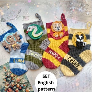 Op de afbeelding: Een set van vier handgehaakte kerstsokken. Elke sok heeft een ander huismascotte en naam: Luna, Draco, Harry en Cedric. De sokken zijn in verschillende kleuren, waaronder blauw, groen, rood, geel en grijs.