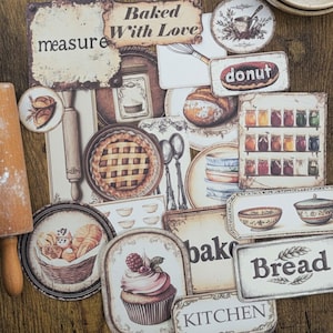 May include: A collection of vintage-style baking-themed paper cutouts. The cutouts feature illustrations of baked goods like pies, bread, and cupcakes, along with kitchen tools and phrases such as "Baked With Love" and "Bread".