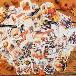 May include: A collection of autumn-themed paper ephemera and stickers featuring illustrations of books, pumpkins, falling leaves, sunflowers, bicycles, and people reading. The designs include text labels like 'fall reading day', 'books & coffee', and 'autumn leaves'.