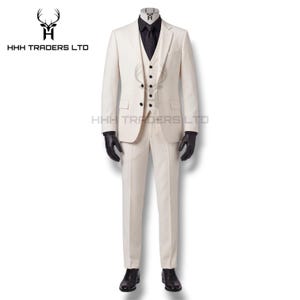 Puede incluir: Un traje crema de tres piezas con camisa y corbata negras. El traje incluye una americana, un chaleco y un pantal&oacute;n. Guantes y zapatos negros completan el conjunto. El logotipo "HHH TRADERS LTD" es visible.