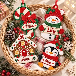 May include: Four embroidered Christmas ornaments featuring a candy cane with the name Mia, a snowman with the name Lily, a gingerbread house with the name Ava, and a penguin with the name Mia, all with red, green, and white details.