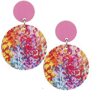 Könnte beinhalten: Ein Paar runde, baumelnde Ohrringe in Pink und Mehrfarbig. Die Ohrringe haben einen rosa Kreis oben und einen größeren Kreis mit einem bunten, abstrakten Blumenmuster.