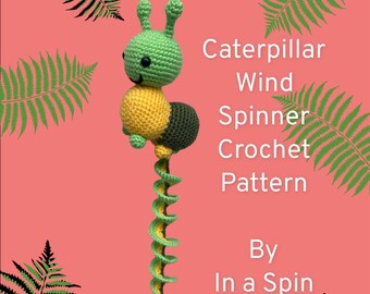 Puede incluir: Un móvil de viento de oruga de ganchillo en verde, amarillo y negro. La oruga cuelga de un cordón en espiral. El texto "Caterpillar Wind Spinner Crochet Pattern By In a Spin Crochet" está escrito sobre un fondo rosa.