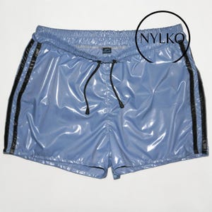 May include: Light blue athletic shorts with black stripes down the sides. The shorts have a drawstring waist and a shiny, reflective finish. The brand name "NYLKO" is visible on the upper right.