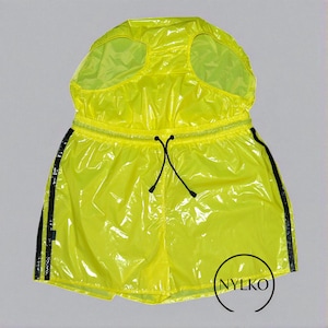May include: Bright yellow, hooded athletic shorts with black side stripes and a drawstring waist. The shorts have a shiny, waterproof appearance. The brand name "NYLKO" is printed in a circle on the lower right side.