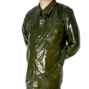 Op de afbeelding: Olijfgroen overhemd met knopen en twee borstzakken. Het shirt met lange mouwen heeft een klassieke kraag en knoopsluitingen. Het materiaal lijkt een lichte, mogelijk synthetische stof te zijn. Waterdicht uiterlijk.