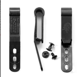 May include: Black plastic belt clip with a skull and crossbones design. The clip has four holes for attaching to a belt. The clip is accompanied by two black screws and a washer.