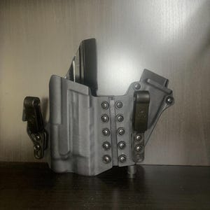 Puede incluir: Funda de polímero negro con inclinación y altura ajustables. La funda tiene un clip lateral y varios tornillos para la personalización.