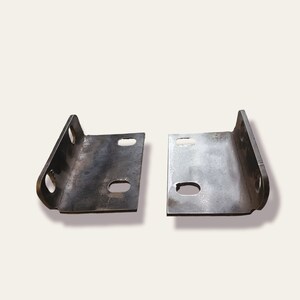 K&ouml;nnte beinhalten: Zwei Metallwinkel mit L&ouml;chern zur Montage. Die Winkel sind aus dunklem Metall und haben eine leicht gekr&uuml;mmte Form.