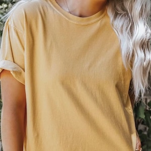 K&ouml;nnte beinhalten: Ein schlichtes, &uuml;berdimensioniertes, gelbes T-Shirt mit hochgekrempelten &Auml;rmeln.