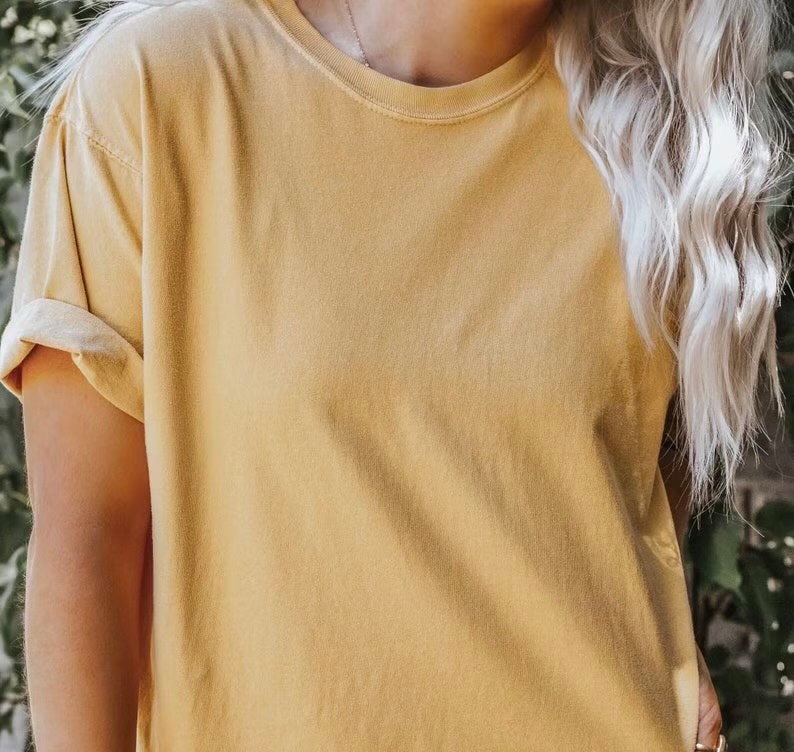 K&ouml;nnte beinhalten: Ein schlichtes, &uuml;berdimensioniertes, gelbes T-Shirt mit hochgekrempelten &Auml;rmeln.