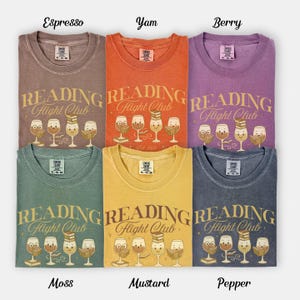 Puede incluir: Seis camisetas en colores espresso, yam, berry, musgo, mostaza y pimienta. Cada camiseta presenta el texto "READING Flight Club" y una ilustraci&oacute;n de copas de vino con libros. Cuello redondo.