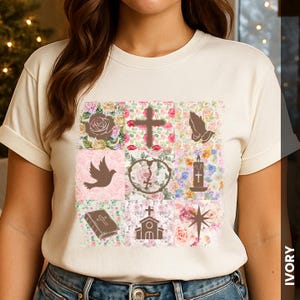 May include: Ivory t-shirt with a patchwork design of religious symbols. The design includes a cross, praying hands, a dove, a church, a bible, a rose, a candle, and a star, set against a floral background.