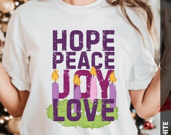 May include: White t-shirt with the words "HOPE PEACE JOY LOVE" in a purple, distressed font. Below the words are purple candles with yellow flames, set on a green wreath. A festive design for the holiday season.