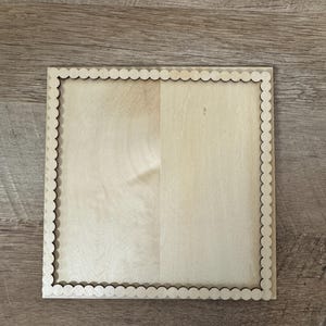 May include: A square, unfinished wooden coaster with a scalloped edge. The coaster is made of light-colored wood and has a natural wood grain pattern. The coaster is approximately 6 inches by 6 inches.