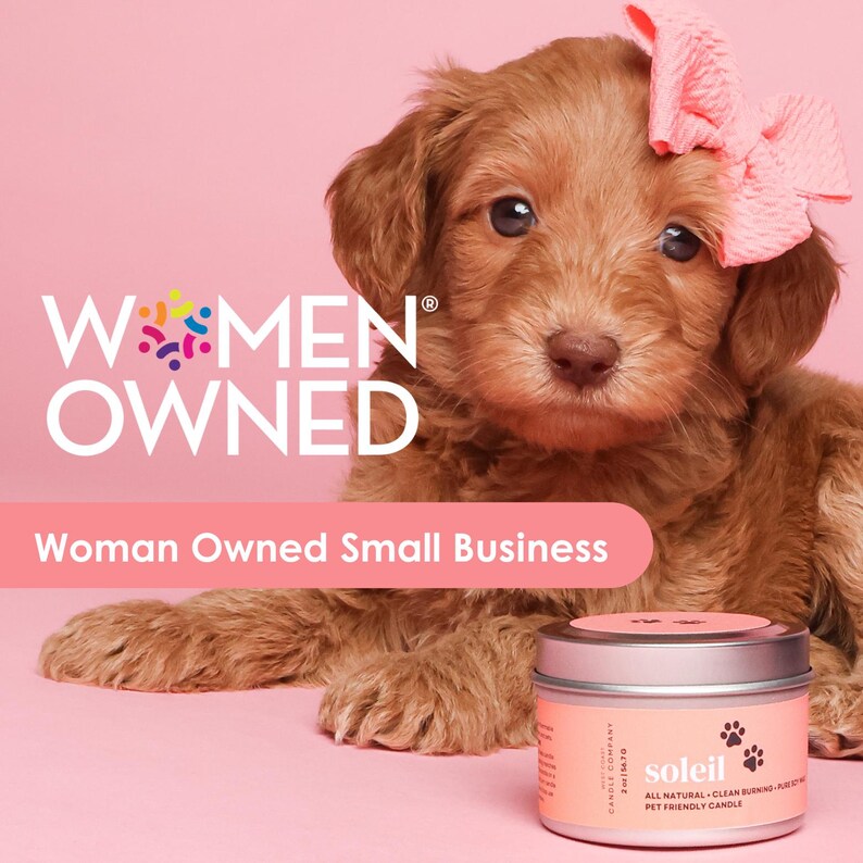 May include: A light brown puppy with a pink bow on its head, next to a small candle. The candle has a silver lid and a pink label with the word "soleil" and paw prints. Text on the image reads "WOMEN OWNED" and "Woman Owned Small Business."