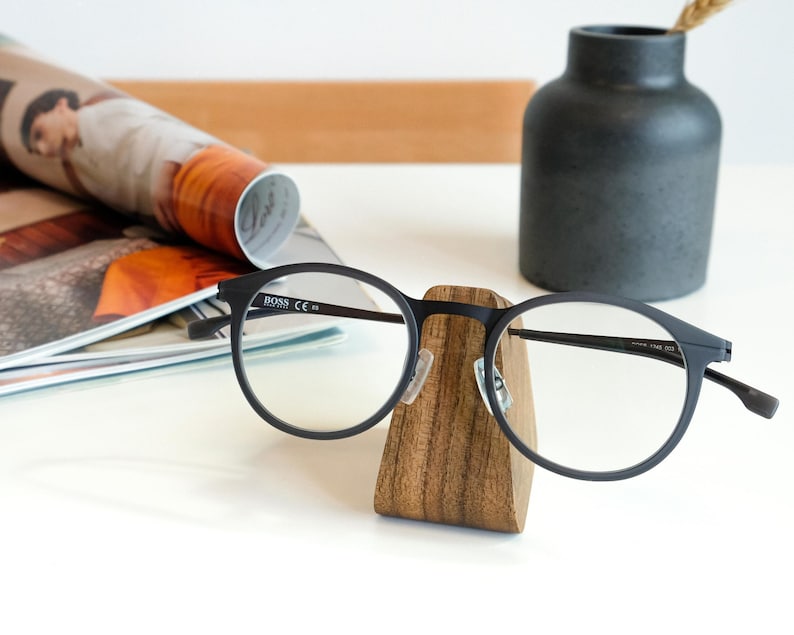 a pair of glasses sitting on top of a wooden stand