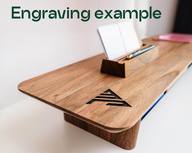 a wooden desk with a notepad and pen on it