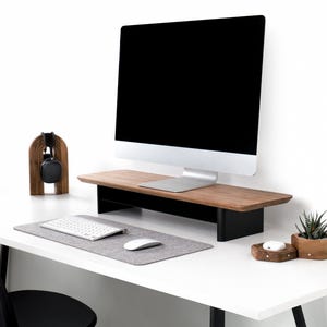 a desk with a computer monitor, keyboard and mouse